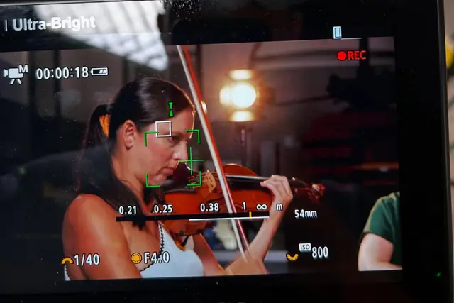 Monitor de câmara a gravar uma violinista em plano aproximado